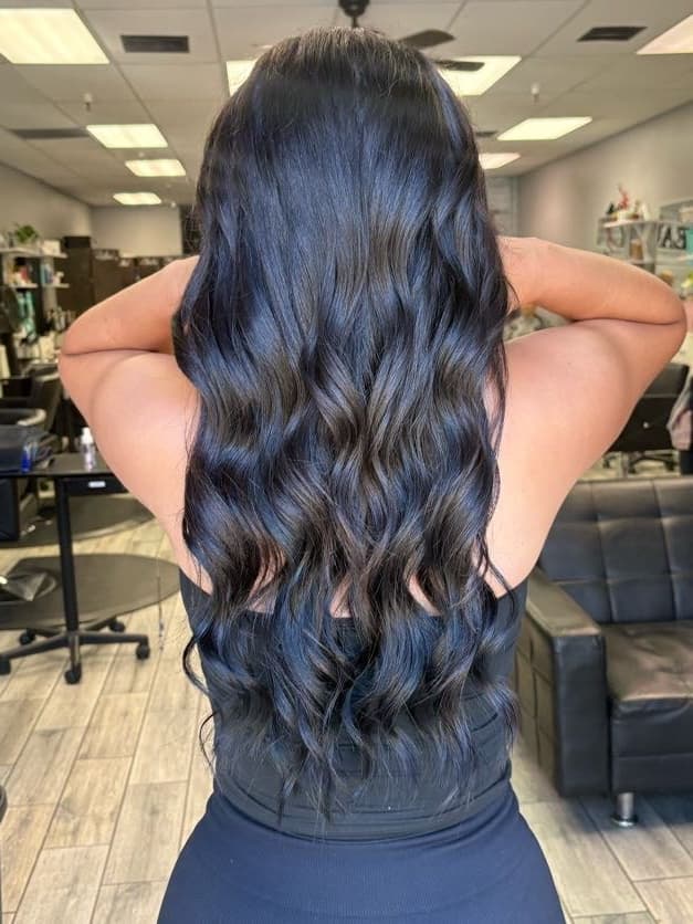 Long dark wavy hair extensions, back view
